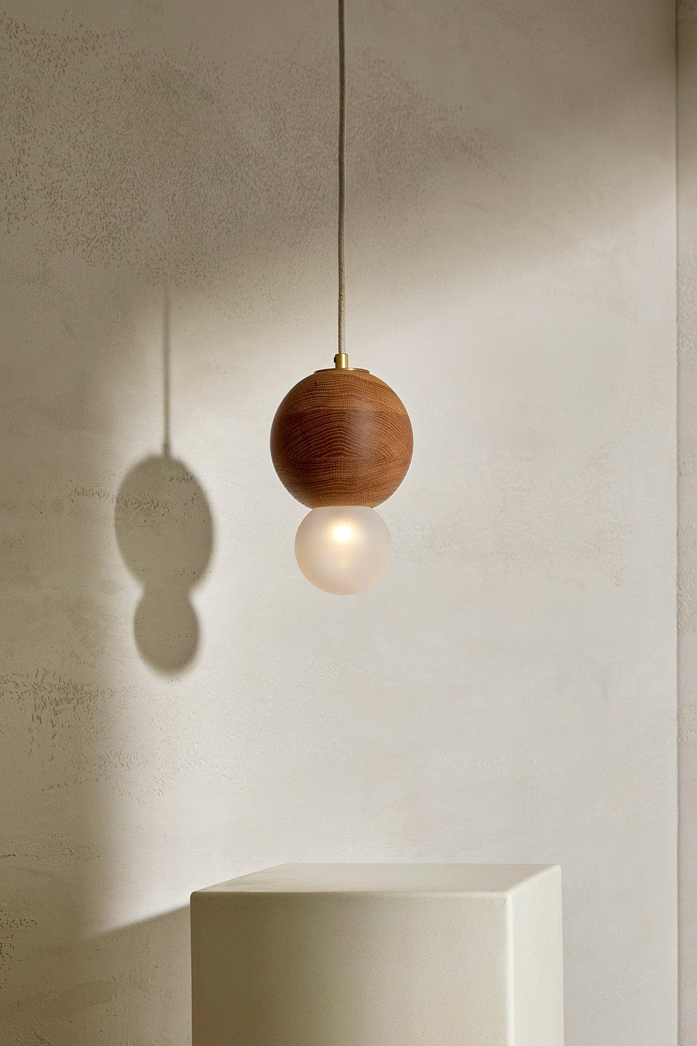 Marz Designs Bright Beads Sphere Pendant Light w/ Fabric in Brass/Oak with the light on.