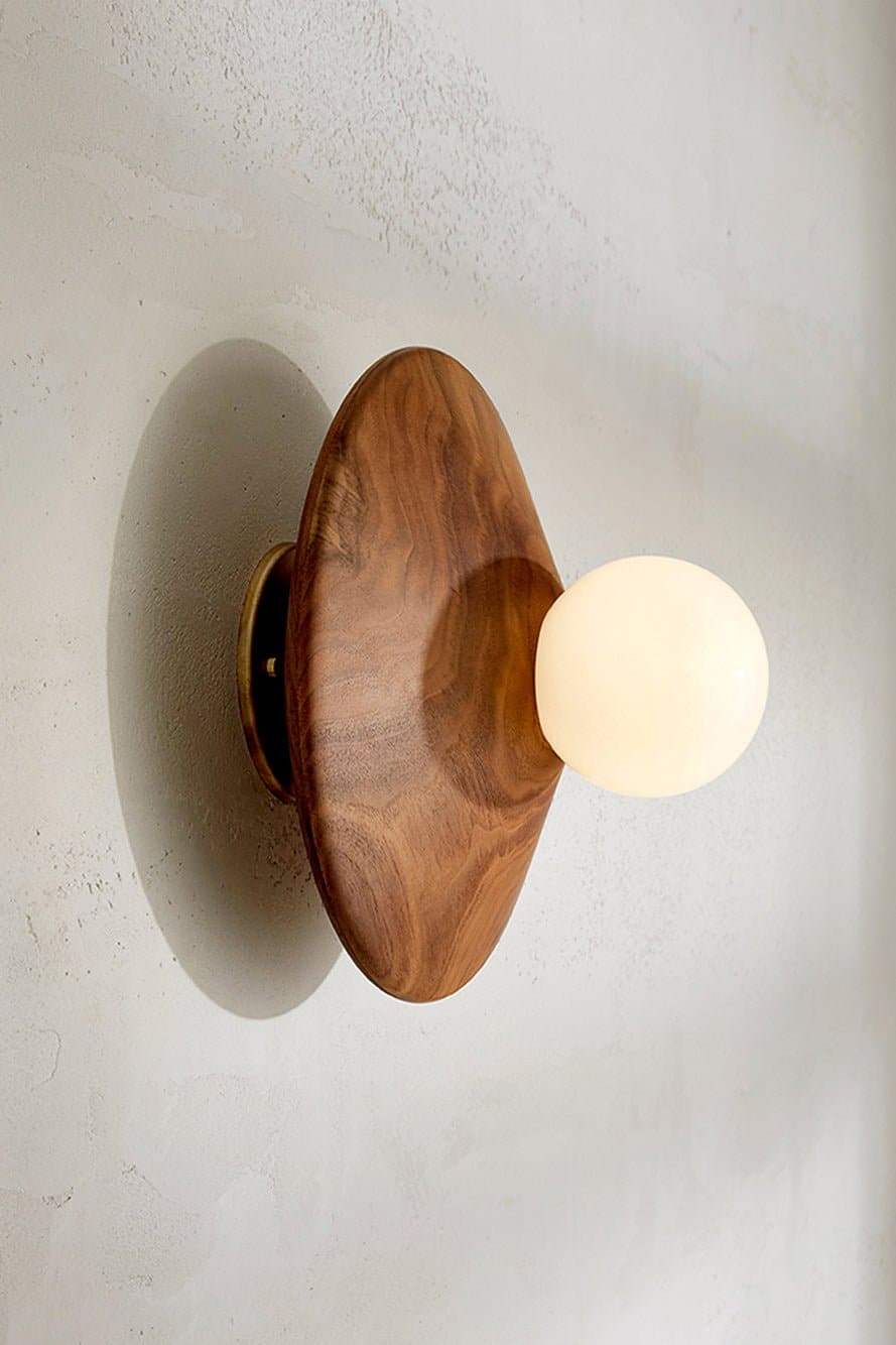 Marz Designs Bright Beads Disc Wall Light in Walnut/Brass with the light on.