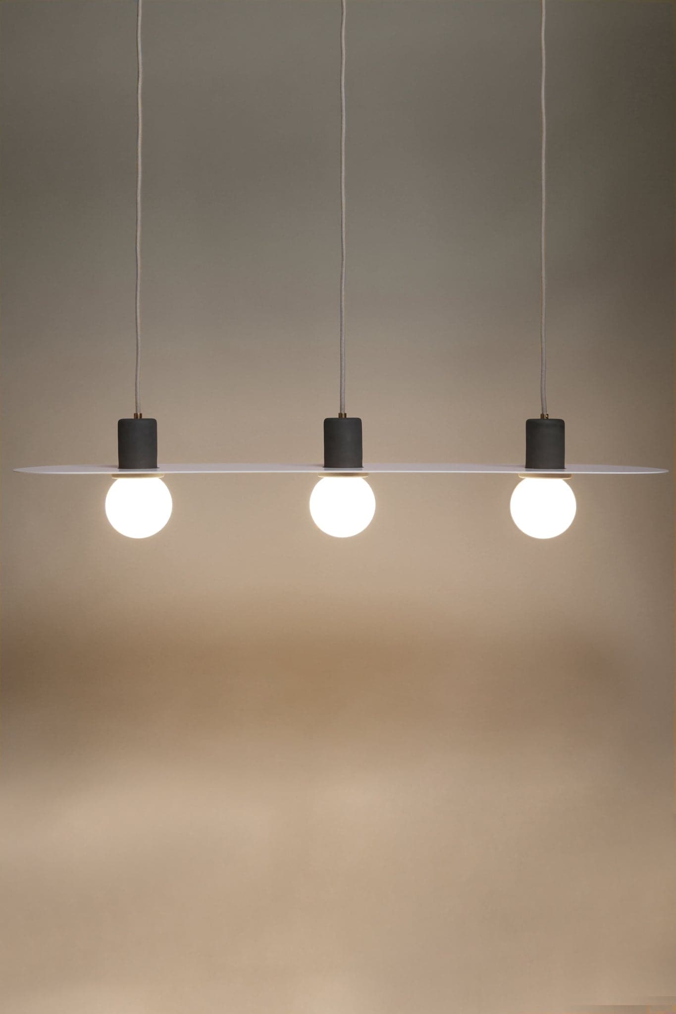 Marz Designs Feature Lighting - Lune Pendant Light in Slate/Brushed Brass with the light on.