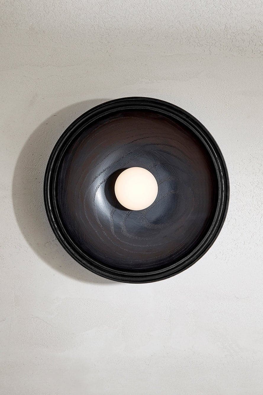 Marz Designs - Selene Surface Sconce Large in Blackened Ash with the light on.